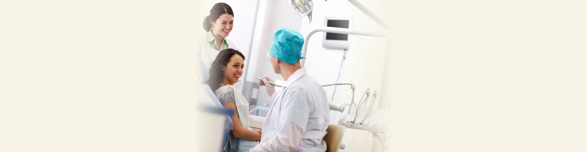 Cheerful patient receiving dental care from a friendly doctor and his assistant